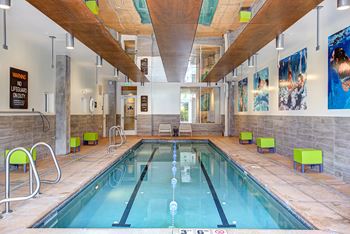 Large indoor swimming pool with a wooden ceiling